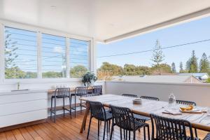 une cuisine et une salle à manger avec une table et des chaises dans l'établissement Sandhurst - oceanstays, à Yamba