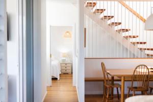 - une cuisine et une salle à manger avec une table et des escaliers dans l'établissement Sandhurst - oceanstays, à Yamba
