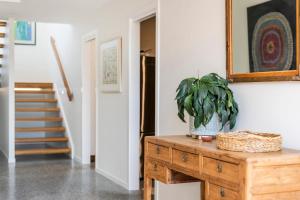 une plante assise au-dessus d'une table en bois dans une pièce dans l'établissement Sandhurst - oceanstays, à Yamba 33 autres photos