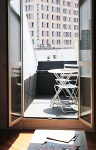 una silla en el balcón con vistas a un edificio en ComeCasa Attic 5 min walk from Duomo, en Milán
