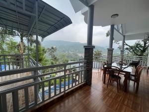 a balcony of a house with a table and chairs at Munnar Blue Mist in Munnar