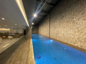 an indoor swimming pool with blue water in a building at Five Stars Suites - Paris - Quito in Quito