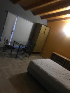 1 dormitorio con 1 cama, mesa y sillas en Casa La Loberia en La Lobería