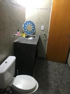 a bathroom with a toilet and a sink and a mirror at Casa La Loberia in La Lobería