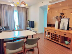 een woonkamer met een eettafel en een grote spiegel bij MIO Masteri Thao Dien Serviced Apartment in Ho Chi Minh-stad