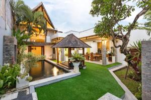 una imagen de un patio trasero con una piscina y una casa en Buddha Beach Villa Seminyak, en Seminyak