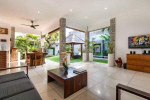 una sala de estar con un sofá y una mesa en Buddha Beach Villa Seminyak, en Seminyak
