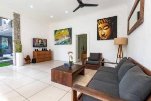 una sala de estar con un sofá y una mesa en Buddha Beach Villa Seminyak, en Seminyak