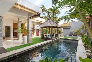 Una piscina al aire libre con un cenador junto a una casa. en Buddha Beach Villa Seminyak, en Seminyak