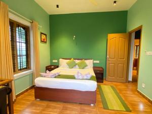 a bedroom with green walls and a bed with pink bows at Munnar Blue Mist in Munnar