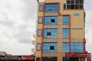 a tall building with windows on the side of it at OYO Flagship Hotel J.B. Paradise in Vānivilāsa Puram