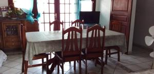 une table à manger avec des chaises et une table avec un tissu de table dans l'établissement LE ZAGOUTI, à Capesterre