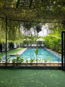- une piscine avec pergola à côté d'un complexe dans l'établissement Lime villa, à Hội An
