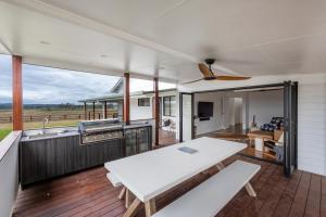 a kitchen and living room with a white table at Farmstay -LJHooker Yamba in Maclean