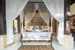 The Kayon Valley Resort في أوبود: غرفة نوم بسرير مع مظلة