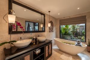 ein Badezimmer mit zwei Waschbecken und einem großen Spiegel in der Unterkunft The Kayon Valley Resort in Ubud