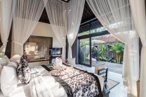 a bedroom with a bed and a large window at The Kayon Valley Resort in Ubud