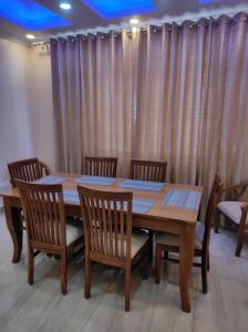 a wooden table with four chairs around it at Superb Luxury Three Bed Apartment in Shimla