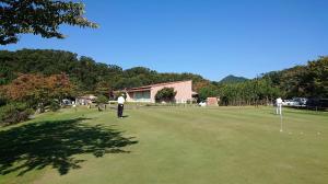 a group of people playing golf on a putting green at HOTEL GEN 猪名川店 