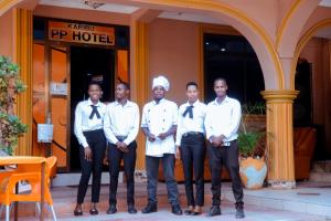 un grupo de hombres en corbatas parados frente a un hotel en Port Park Hotel, en Mwanza