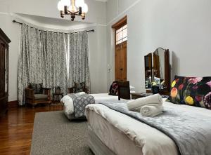 a bedroom with two beds and a chandelier at Ramble Guest House in Riversdale