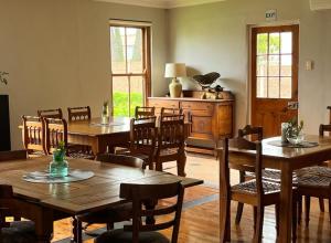 a dining room with wooden tables and chairs at Ramble Guest House in Riversdale