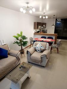 a living room with two couches and a table at Departamento familiar en Huacachina in Ica