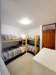 a room with two bunk beds and a door at Departamento familiar en Huacachina in Ica