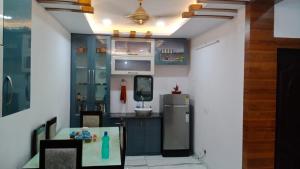 a kitchen with a refrigerator and a table at Sindhu Villa in Lucknow