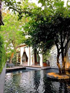 ein Haus mit einem Swimmingpool und einem Baum davor in der Unterkunft The Journey Resort Pattaya in Na Jomtien