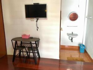 a small table and a sink and a television on a wall at Baan Fun Dee Chiang Khan in Chiang Khan