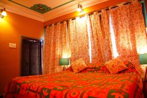 a bedroom with a bed and a window with curtains at Bundi Inn - A Heritage Boutique Haveli in Būndi