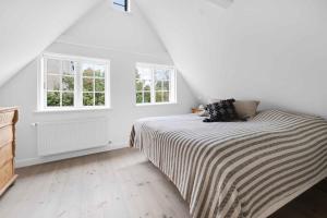 a white bedroom with a bed and two windows at Sndergade 5, rskbing in Ærøskøbing