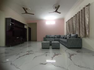 ein Wohnzimmer mit einem Sofa und einem Flachbild-TV in der Unterkunft KPHB Phase 15 New Stunning 3 BHK - 1st Floor in Hyderabad
