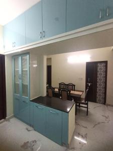 eine Küche mit blauen Schränken und einem Esszimmer in der Unterkunft KPHB Phase 15 New Stunning 3 BHK - 1st Floor in Hyderabad