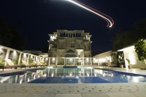 un edificio con piscina por la noche en The Tiger Villa by ATD India - Group of Hotels and Resorts, en Sawāi Mādhopur