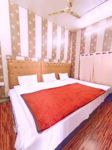 a bedroom with a large bed with a red blanket at Hotel India inn in Agra