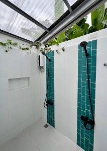 a bathroom with a shower with green tiles at 11th Earth Farm and Resort in Nabua