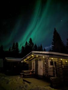 a cabin with the northern lights in the sky at Cottages RukaTupa in Ruka