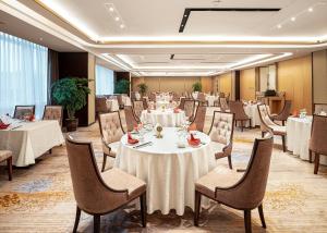 una sala banchetti con tavoli e sedie bianchi di Qin Huang Yong An Boutique Hotel a Chengdu