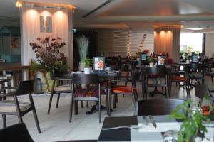 a dining room with tables and chairs in a restaurant at Wyndham Grand Nai Harn Beach Phuket in Nai Harn Beach