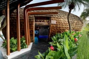 a bar in a building with flowers and plants at Wyndham Grand Nai Harn Beach Phuket in Nai Harn Beach