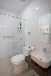 biała łazienka z toaletą i umywalką w obiekcie Sundaze Dormitel w mieście Naga