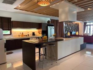 a kitchen with a large island with bar stools at Amatapura Beachfront Villa 10 , SHA Certified in Ao Nam Mao
