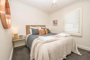 a bedroom with a bed and a window at Orana Cottage in Orange