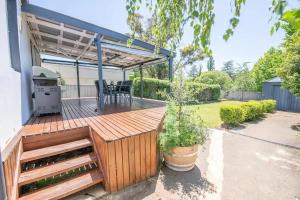 a wooden deck with a pergola in a yard at Orana Cottage in Orange