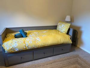 een slaapkamer met een bed met gele lakens en blauwe kussens bij Appartement 109 in Sallanches