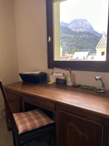 een bureau met een raam in een kamer met een bureau bij Appartement 109 in Sallanches
