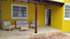 uma casa amarela com duas cadeiras e uma mesa em Casa la Arcada em Oaxaca de Juárez