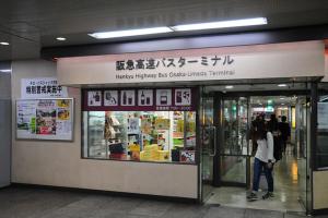 a woman standing in front of a store at Apartment Hotel 11 Umeda in Osaka